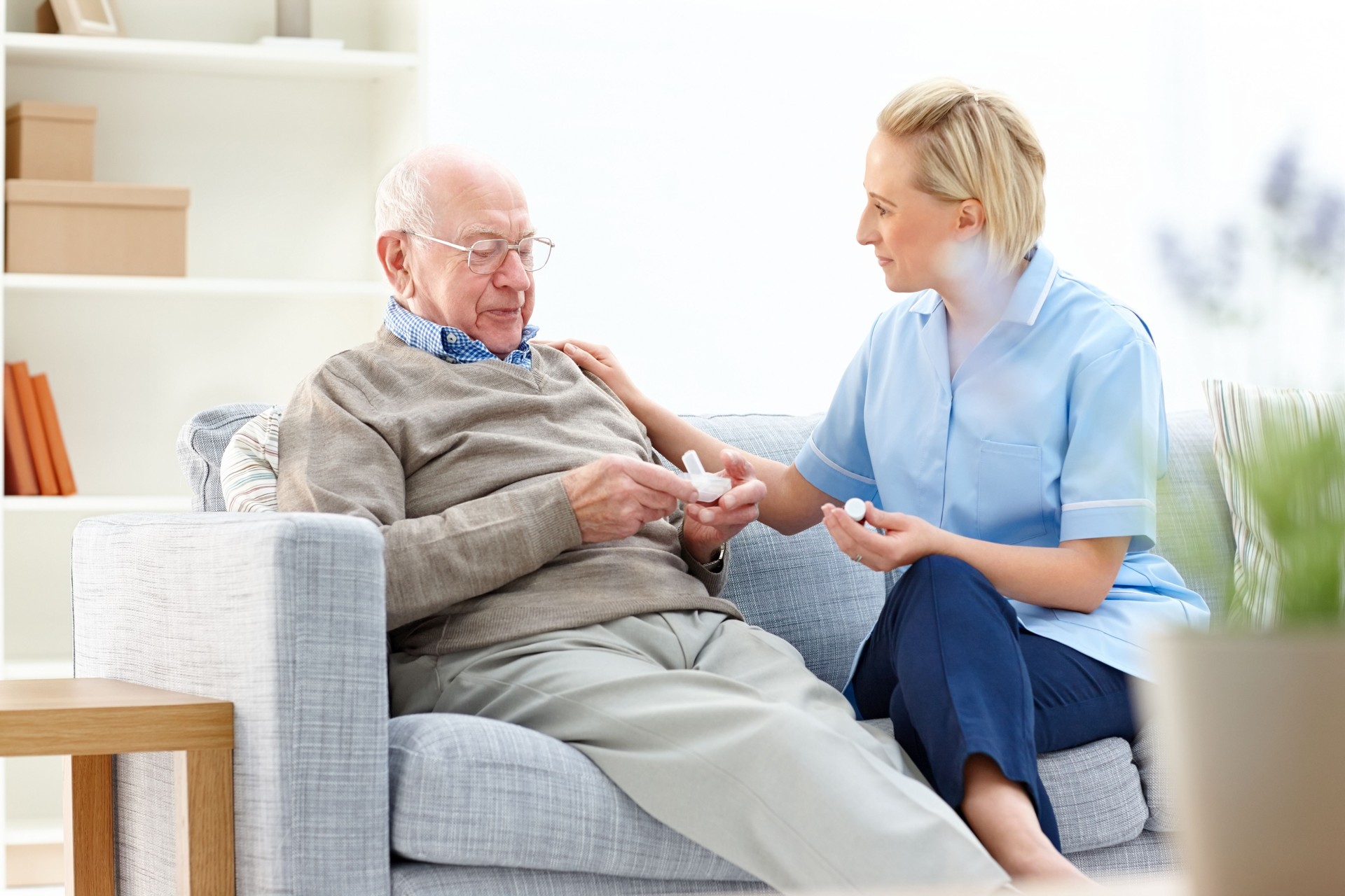 Female nurse giving medication instructions to elderly patient